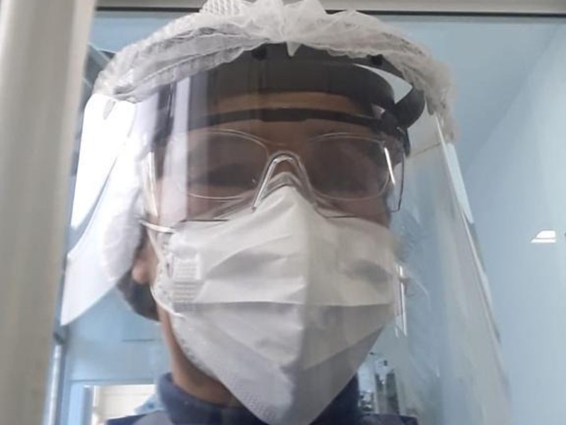 Kátia está paramentada para atender os pacientes da UTI, com toca, máscara, óculos e face shield